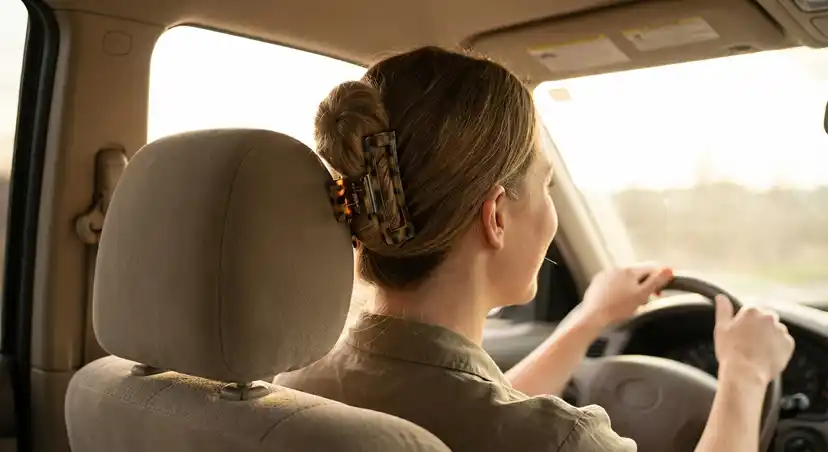 Woman comfortably wearing flat claw clip while driving